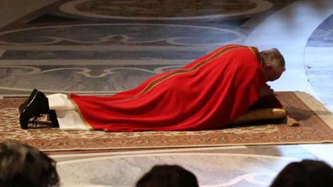 Papa Francesco in preghiera prostrato ai piedi della Croce nella Basilica Vaticana nel giorno del Venerdì Santo